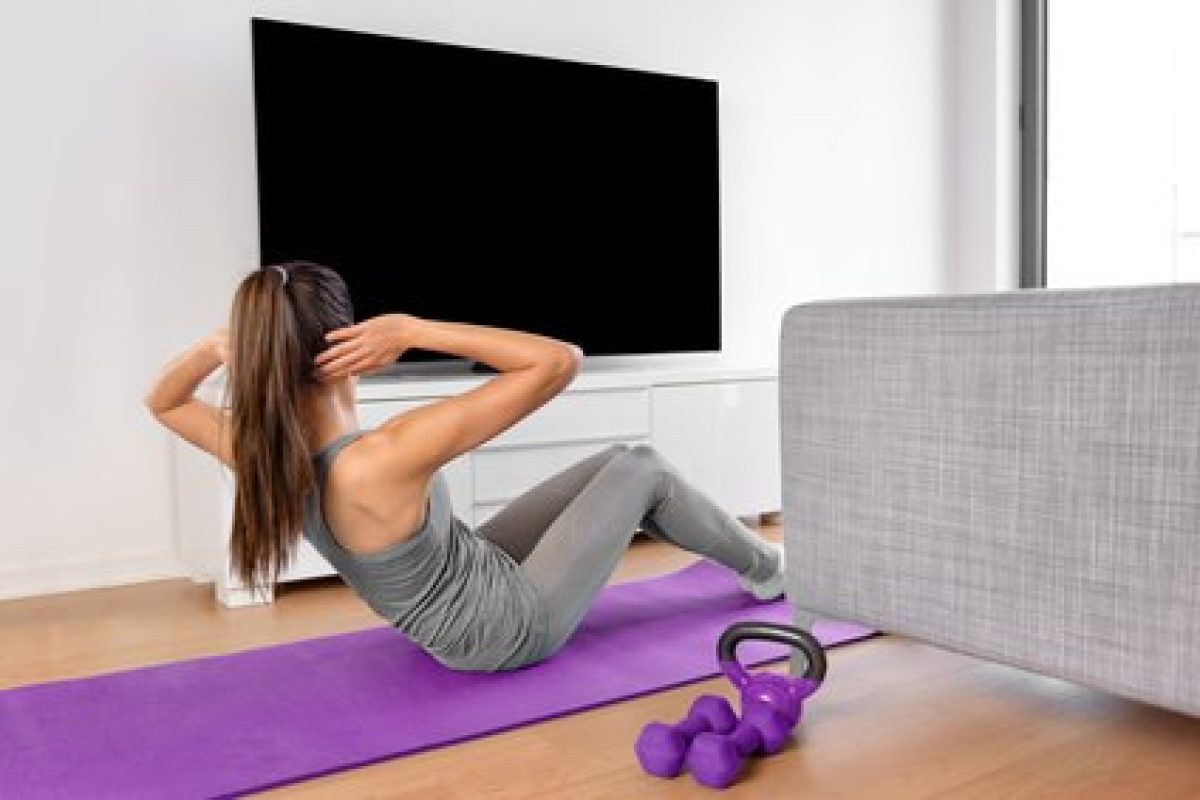 Home fitness woman watching workout videos on tv