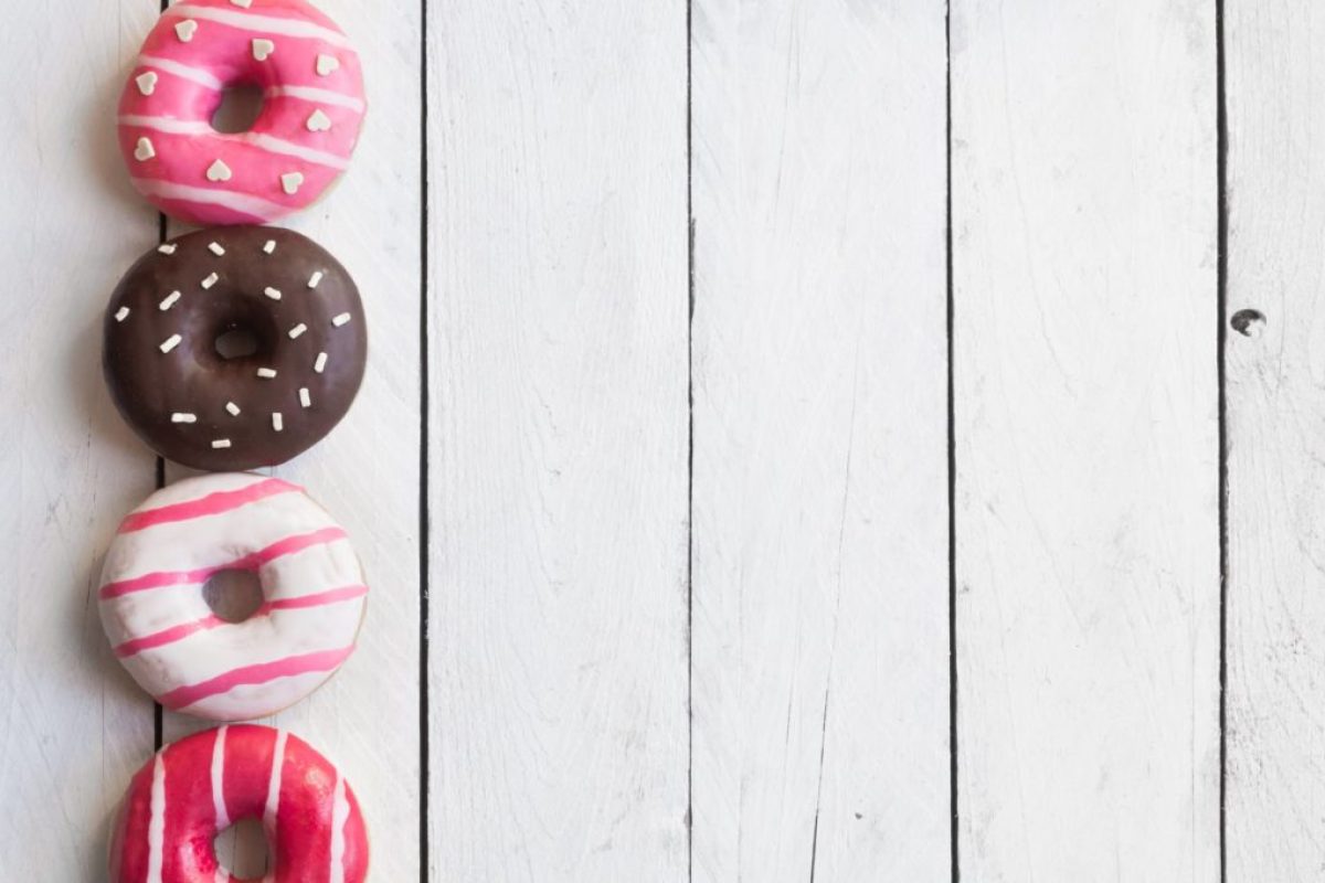 Colorful donuts on white wooden table